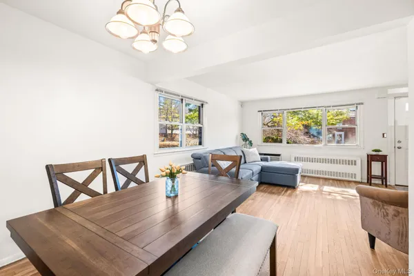 a view of a dining room with furniture a chandelier and wooden floor