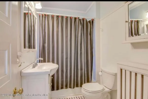 a bathroom with a sink a toilet and shower curtain