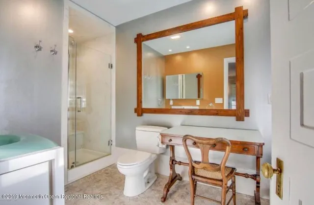 a bathroom with a toilet a sink and a mirror