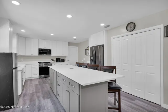 a kitchen with a white refrigerator a sink dishwasher a stove and a refrigerator with wooden floor