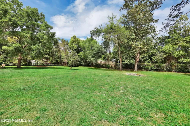 a view of green field with trees in the background