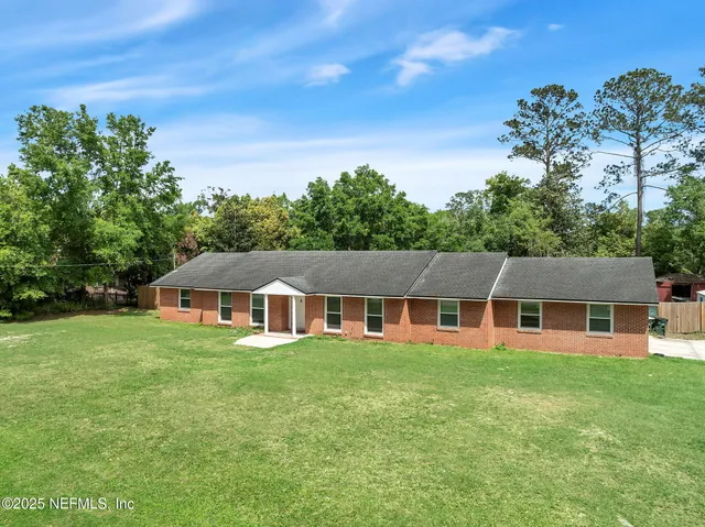 a view of a house with a yard and sitting area