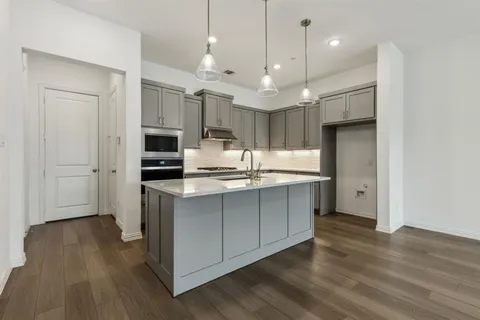 a kitchen with kitchen island a sink stainless steel appliances and cabinets