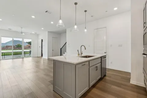 a view of a kitchen with a sink and wooden floor