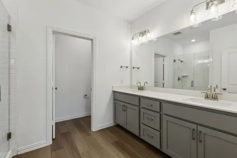a spacious bathroom with a double vanity sink mirror and shower