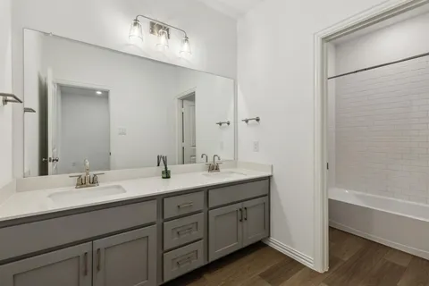 a bathroom with a double vanity sink and mirror
