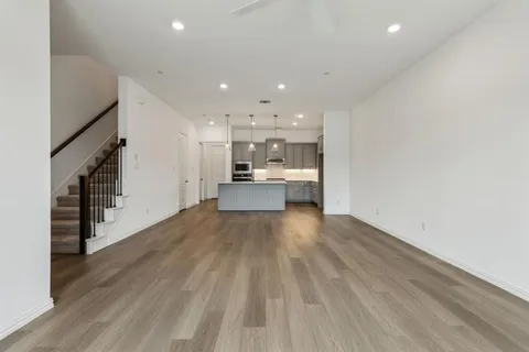 a view of a kitchen with wooden floor and electronic appliances