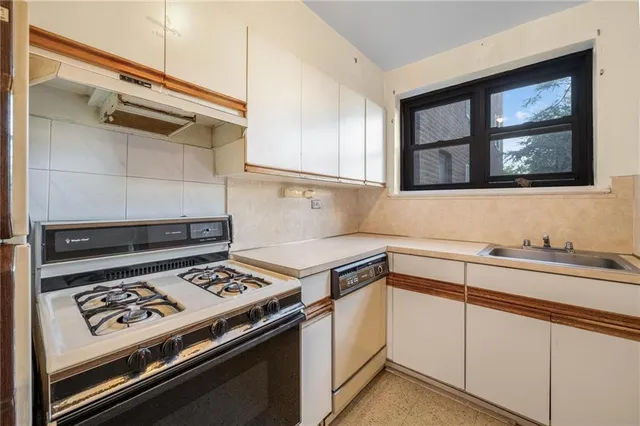a kitchen with white cabinets and appliances