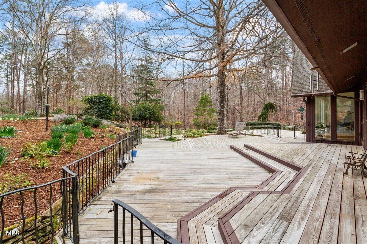 10729 Trego Trail Raleigh, NC 27614 - Photo 50 of 65 An expansive, fully-fenced deck runs along the back of the house.