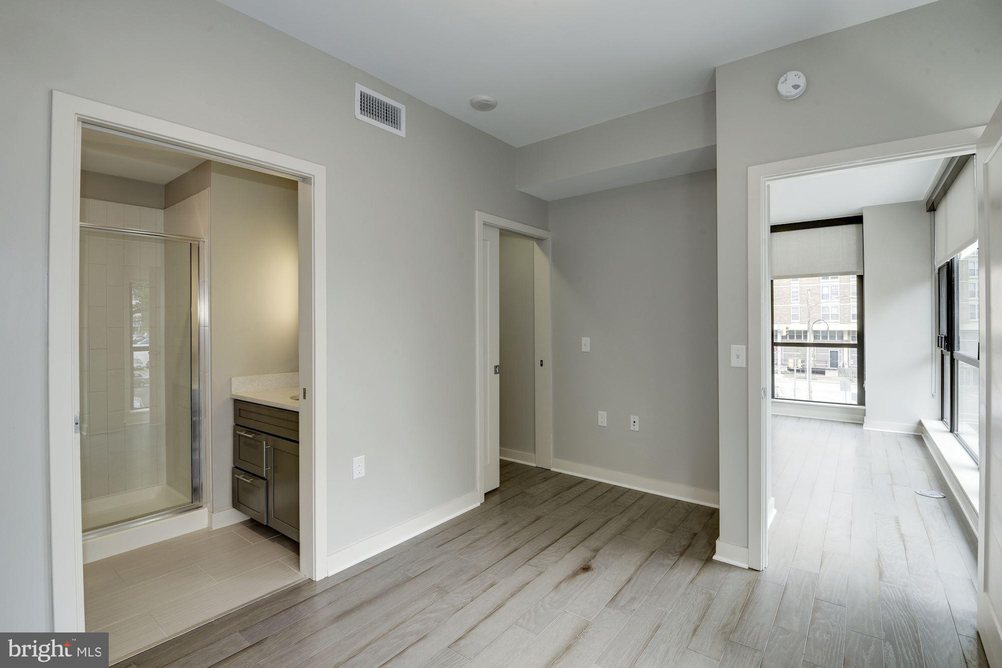 1320 Fenwick Lane, Unit 202 Silver Spring, MD 20910 - Photo 11 of 19 an empty room with wooden floor and a fireplace