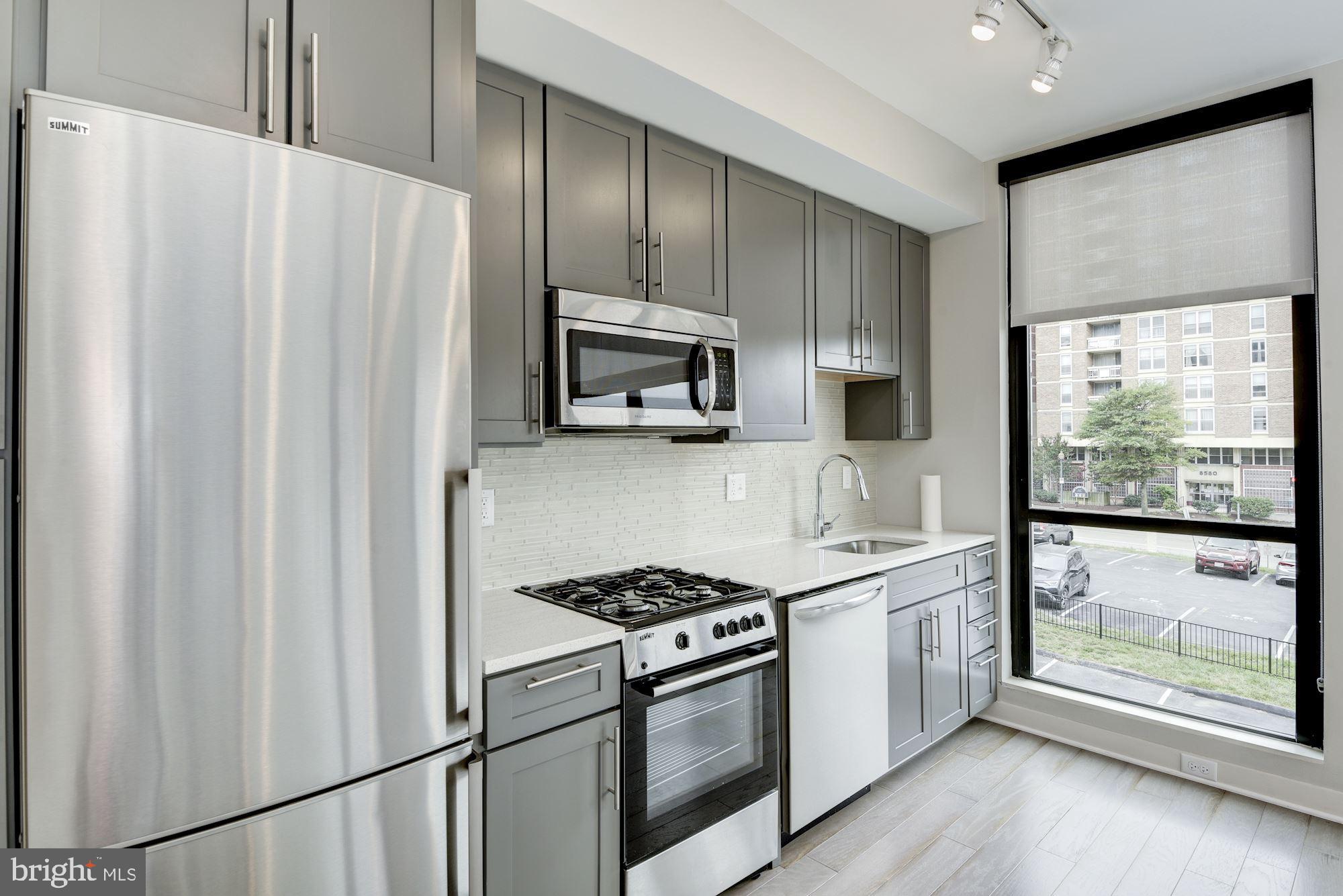 1320 Fenwick Lane, Unit 202 Silver Spring, MD 20910 - Photo 4 of 19 a kitchen with stainless steel appliances a refrigerator sink and cabinets