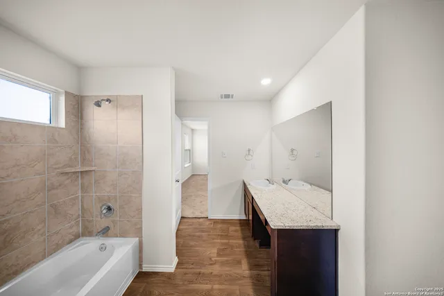 a bathroom with a sink a mirror and a bathtub
