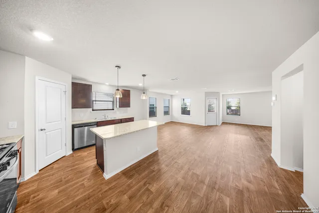 a living room with hard wood floors and a kitchen
