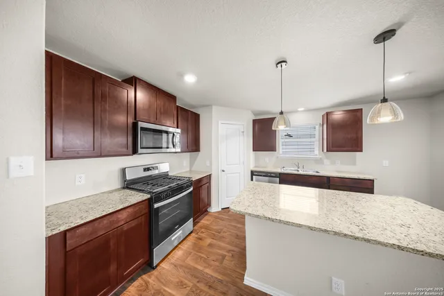 a kitchen with stainless steel appliances granite countertop refrigerator a sink a stove and oven