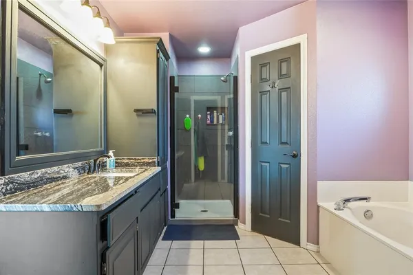a bathroom with a granite countertop sink a mirror and a bathtub