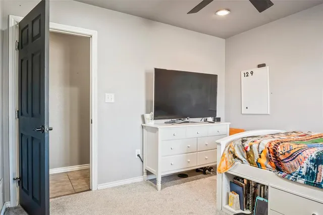 a bedroom with bed and flat tv screen on dresser