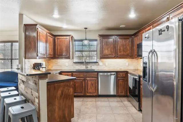 a kitchen with stainless steel appliances granite countertop a refrigerator sink and cabinets