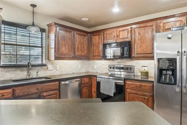 a kitchen with stainless steel appliances granite countertop a stove sink and cabinets