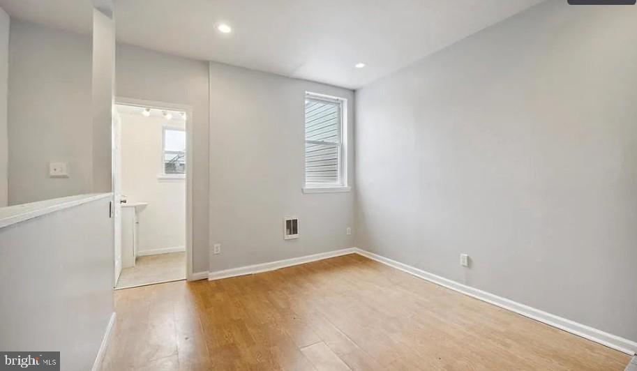 1402 North Newkirk Street, Unit B Philadelphia, PA 19121 - Photo 6 of 9 an empty room with wooden floor and window