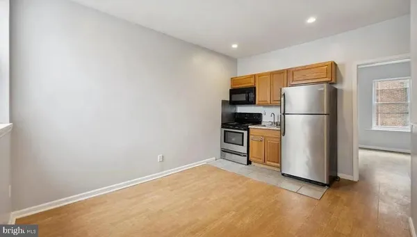 a kitchen with a refrigerator and a stove top oven