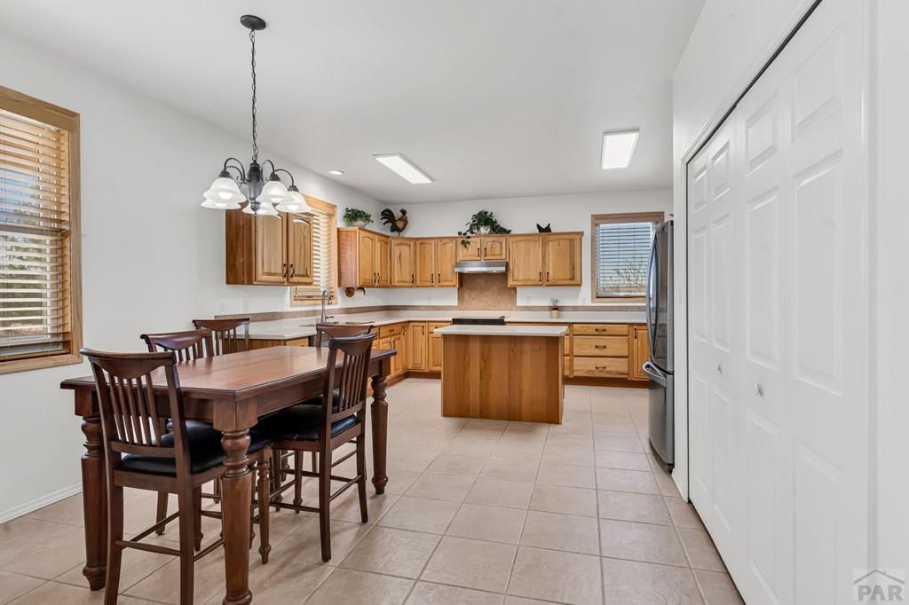 2064 Iris Road Pueblo, CO 81006 - Photo 11 of 56 a kitchen with stainless steel appliances kitchen island a chandelier