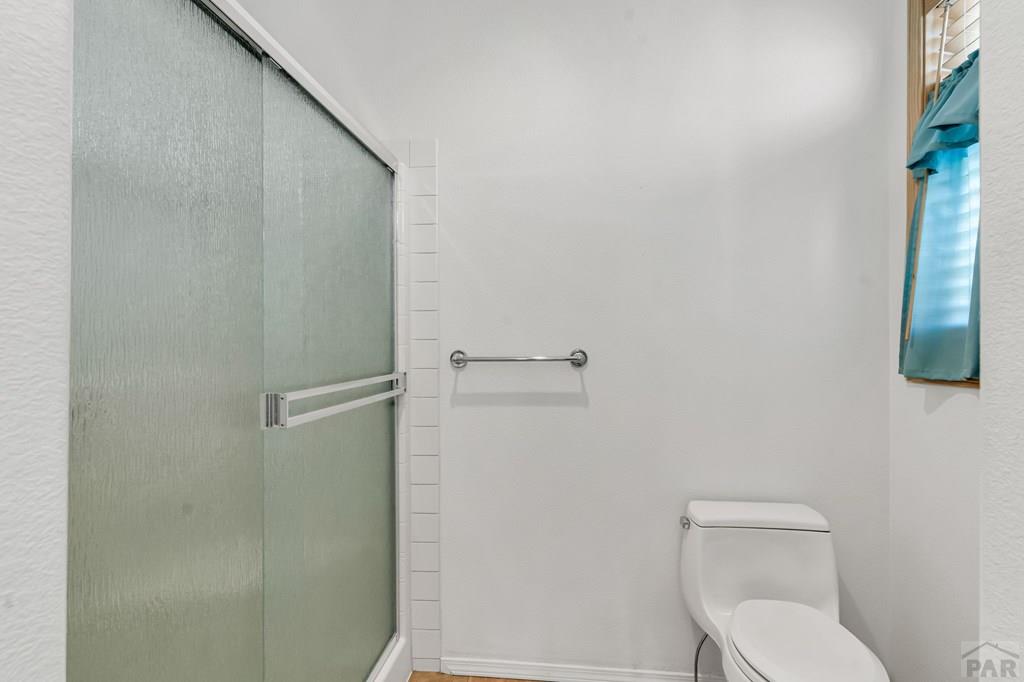 2064 Iris Road Pueblo, CO 81006 - Photo 18 of 56 a white toilet sitting next to a shower
