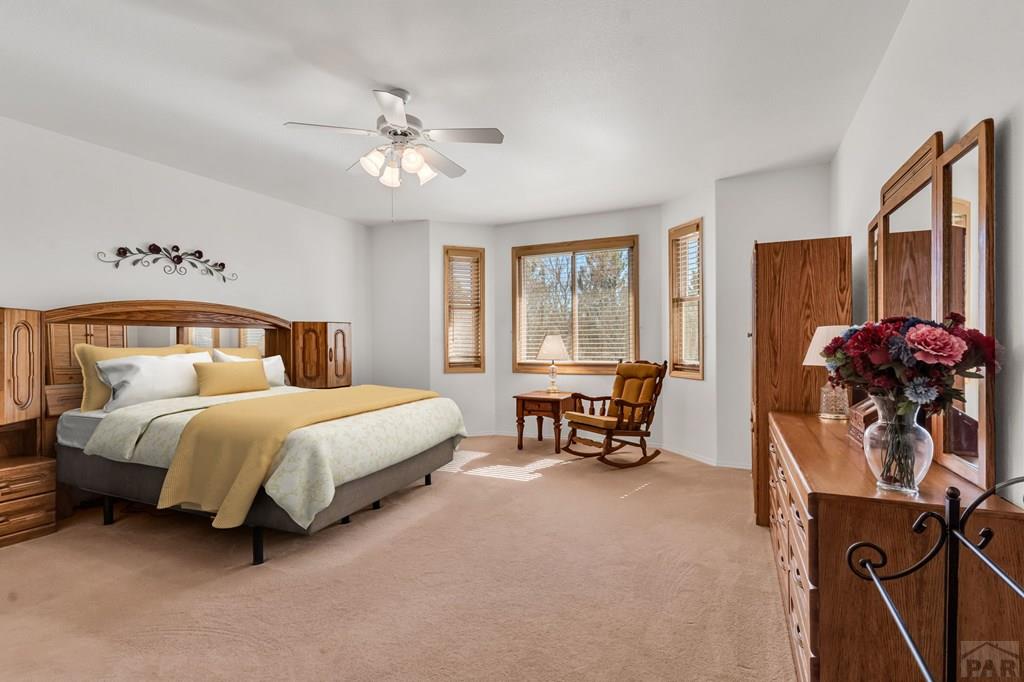 2064 Iris Road Pueblo, CO 81006 - Photo 20 of 56 a bedroom with a bed and a chandelier
