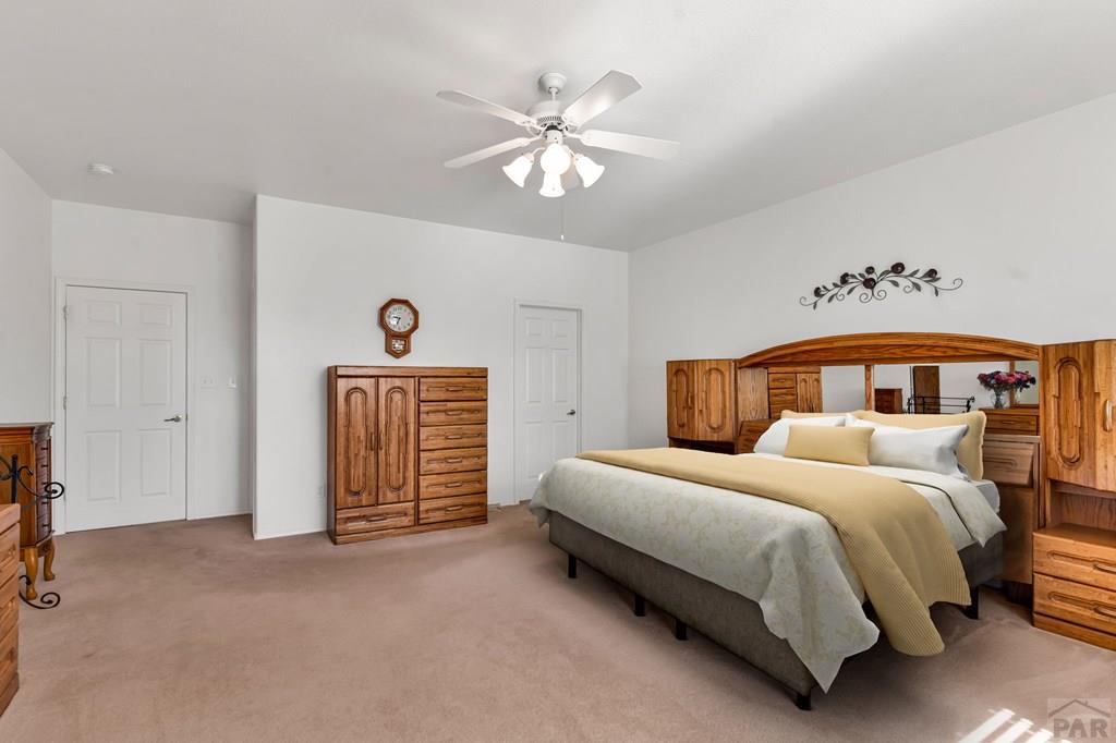 2064 Iris Road Pueblo, CO 81006 - Photo 21 of 56 a bedroom with a bed and a chandelier