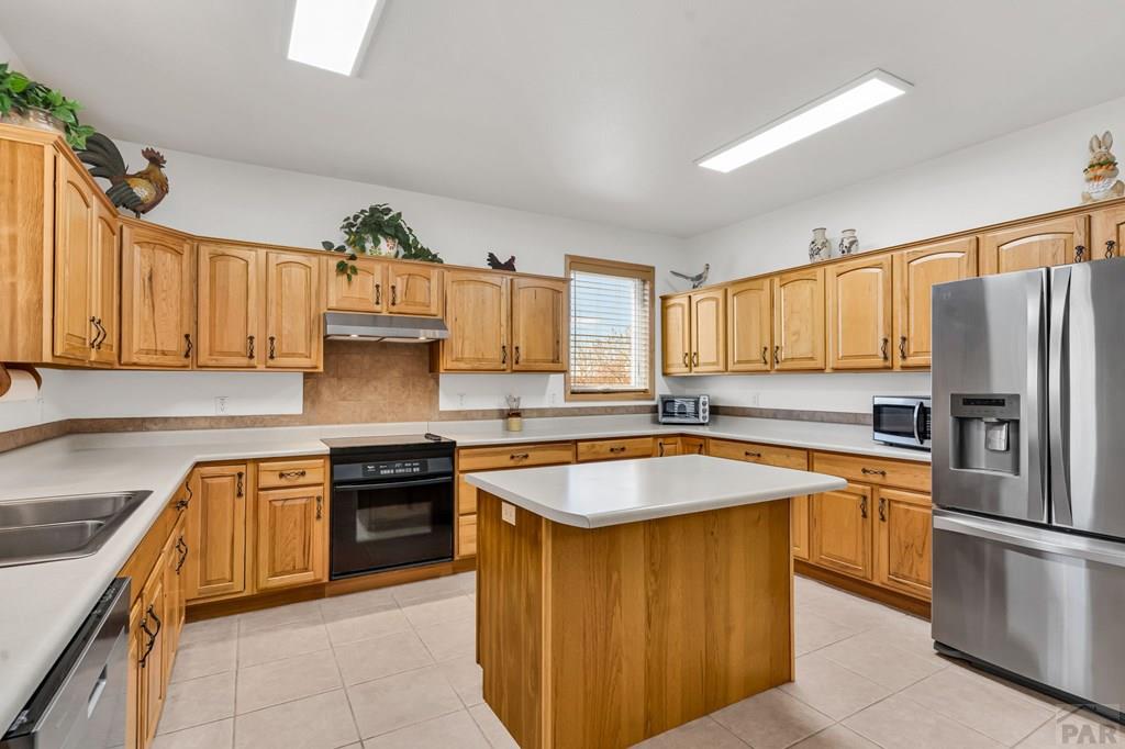 2064 Iris Road Pueblo, CO 81006 - Photo 9 of 56 a kitchen with stainless steel appliances granite countertop a sink stove and refrigerator