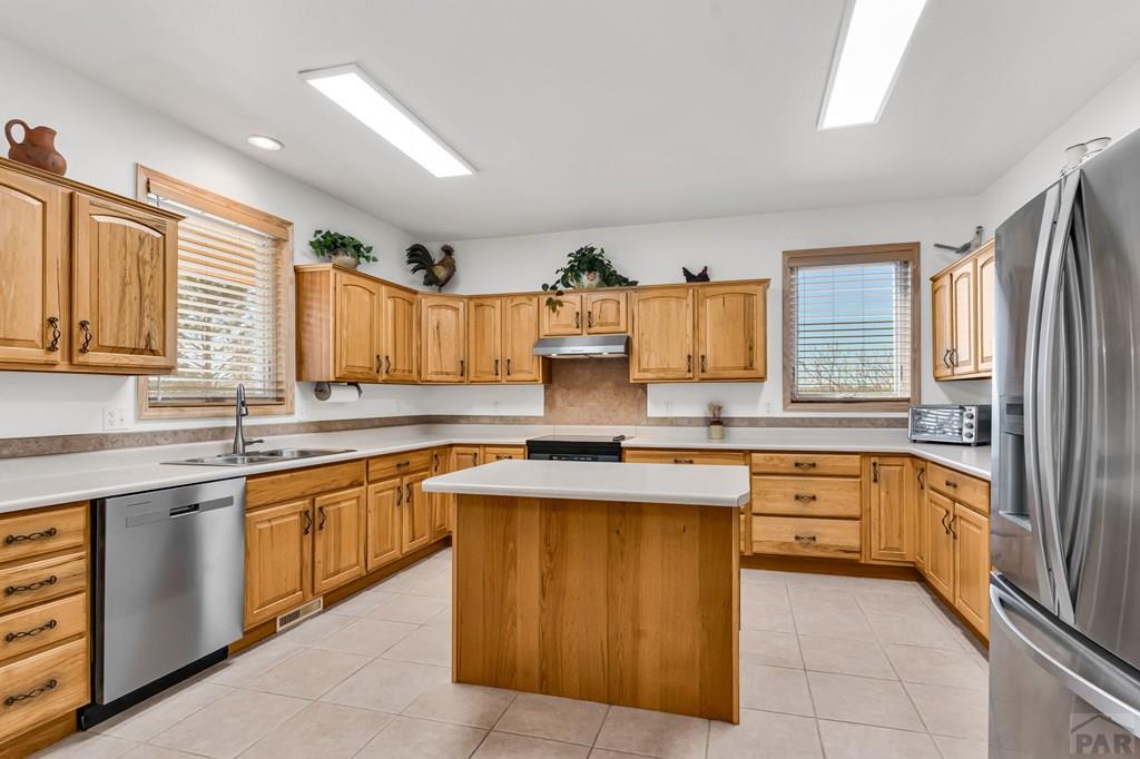 2064 Iris Road Pueblo, CO 81006 - Photo 10 of 56 a kitchen with stainless steel appliances granite countertop a sink and cabinets