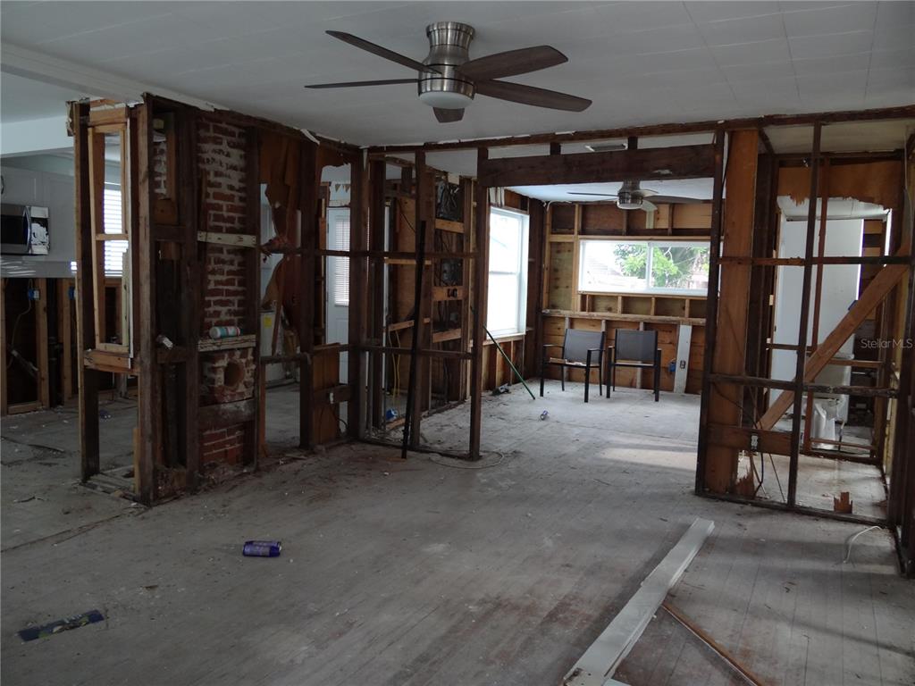 14117 Palm Street Madeira Beach, FL 33708 - Photo 3 of 25 an empty room with ceiling fan and windows