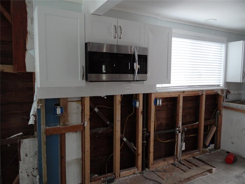 14117 Palm Street Madeira Beach, FL 33708 - Photo 5 of 25 a kitchen with a microwave and a sink