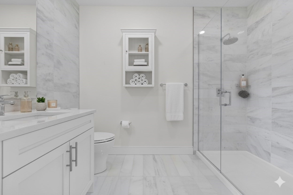 301 Border Street, Unit 411 Boston, MA 02128 - Photo 4 of 14 a bathroom with a granite countertop sink a toilet and shower