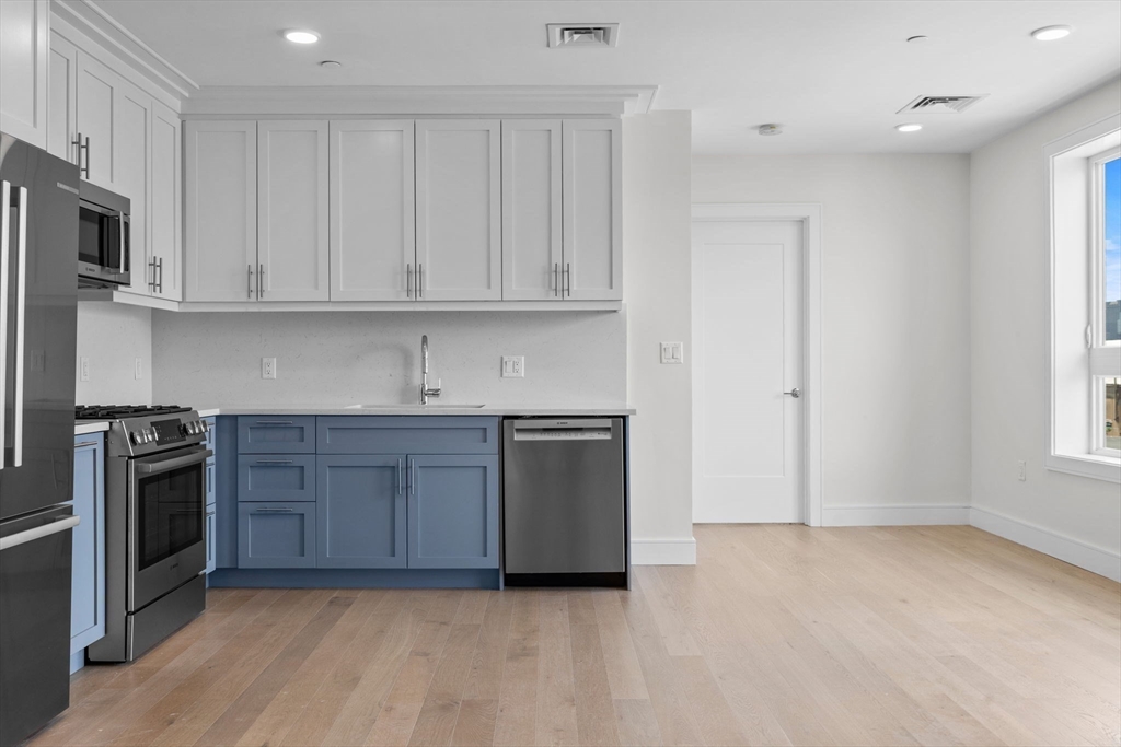 301 Border Street, Unit 411 Boston, MA 02128 - Photo 6 of 14 a kitchen with stainless steel appliances granite countertop a stove a sink and a refrigerator
