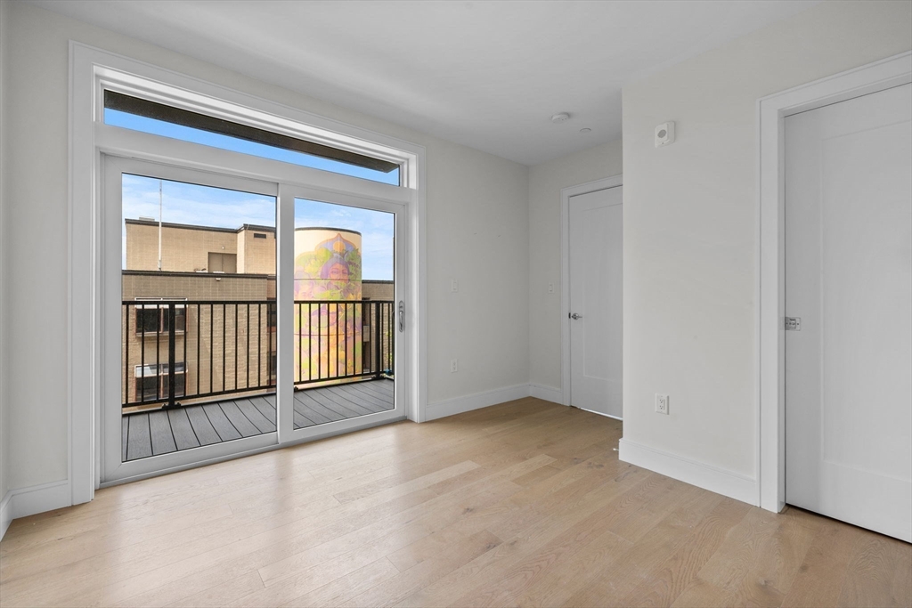 301 Border Street, Unit 411 Boston, MA 02128 - Photo 9 of 14 an empty room with a fireplace and windows