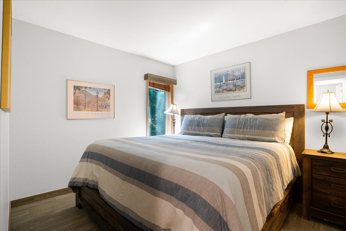 120 Sawmill Road, Unit 106 Breckenridge, CO 80424 - Photo 11 of 25 a bedroom with bed and wall painting with wooden floor