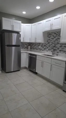 a kitchen with a sink a refrigerator and cabinets
