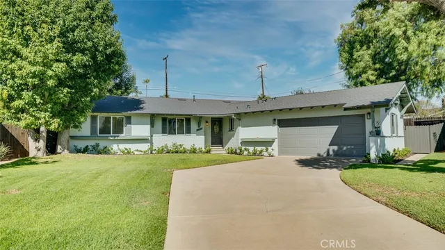 a front view of a house with a yard and trees