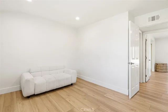 a view of a room with wooden floor and white walls