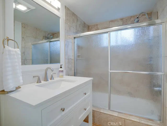 a bathroom with a shower sink and mirror