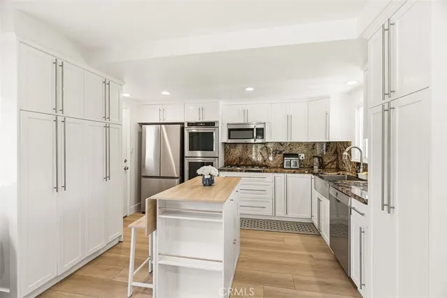 a kitchen with white cabinets and stainless steel appliances