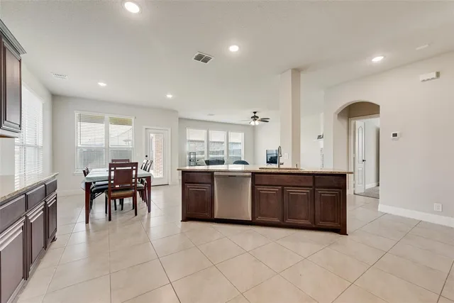 a large kitchen with kitchen island a sink table and chairs