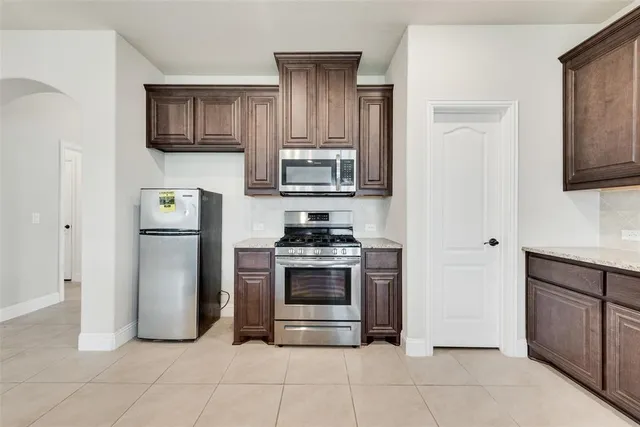 a kitchen with stainless steel appliances granite countertop a stove and a refrigerator