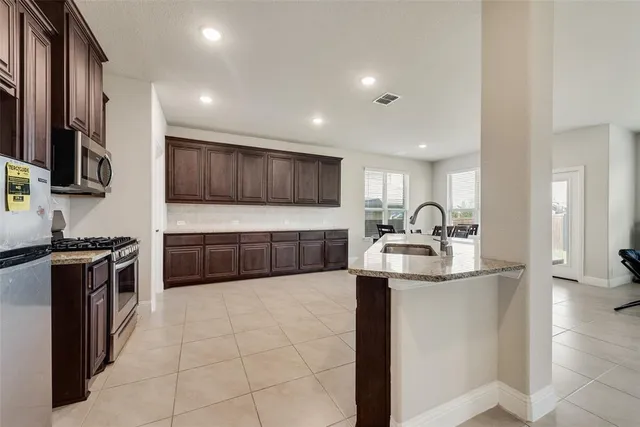 a kitchen with stainless steel appliances granite countertop a sink stove and cabinets