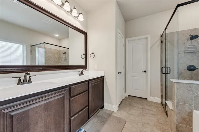 a bathroom with a double vanity sink mirror and shower