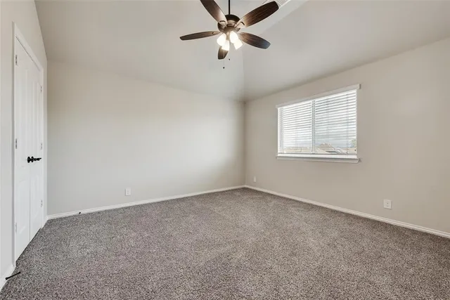 an empty room with a window and a fan