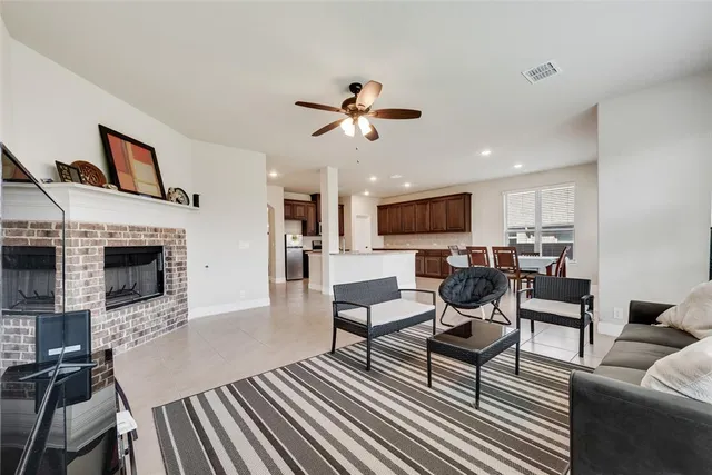 a living room with furniture a fireplace and a flat screen tv