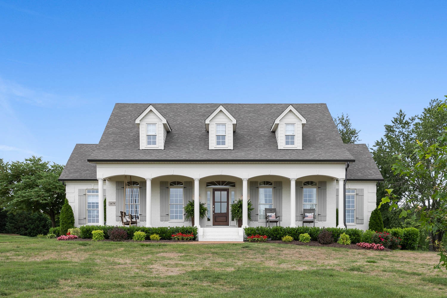 a front view of a house with a garden