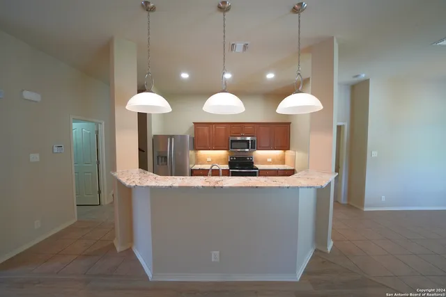 a kitchen with a refrigerator a sink and a large mirror