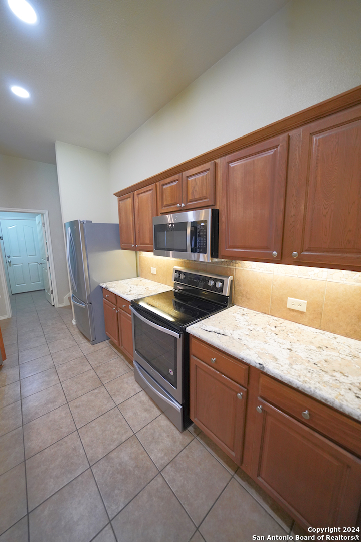 15805 Fair Lane Selma, TX 78154 - Photo 17 of 50 a kitchen with stainless steel appliances granite countertop a sink counter space and cabinets